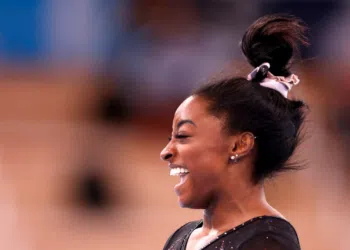 Simone Biles sorrindo durante treino nas Olimpíadas (Crédito: GettyImages)