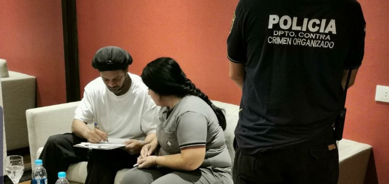 Antes de prestar depoimento no Paraguai, Ronaldinho Gaúcho posa para foto com policial - Públicas/ Fiscália Paraguay
