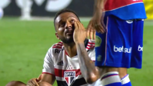 Reinaldo no gramado apontando a mão no olho atingido por Welington Paulista - Transmissão TV Globo