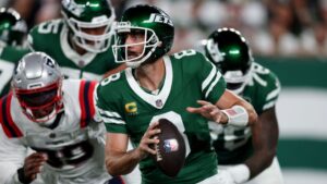 Aaron Rodgers, quarterback do New York Jets, prepara um lançamento em jogo contra o New England Patriots