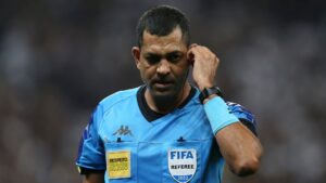 O juiz do jogo, Wagner do Nascimento, ouvindo as considerações do VAR sobre o lance polêmico