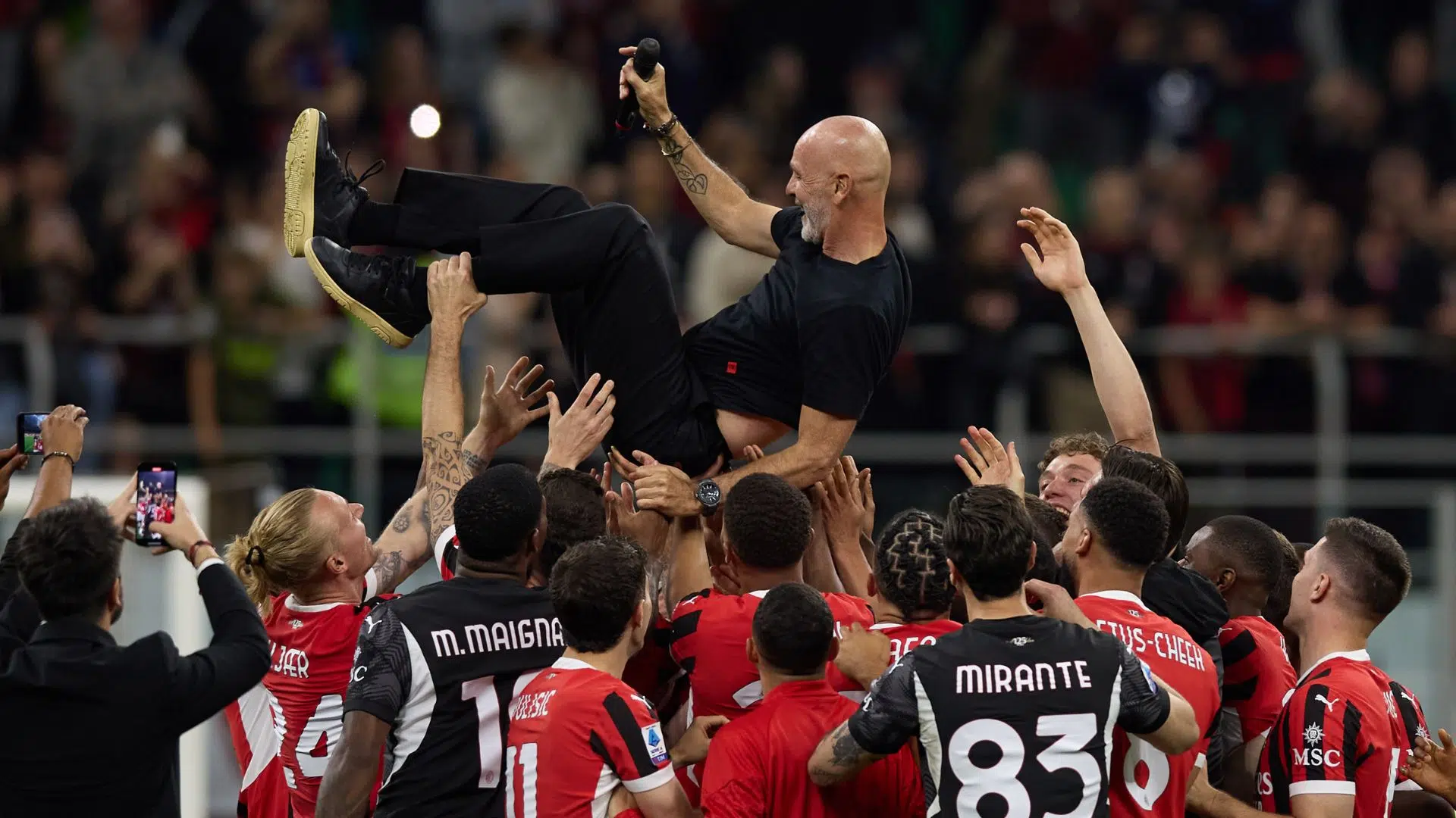 Stefano Pioli sendo jogado para cima pelos jogadores do Milan, em sua despedida