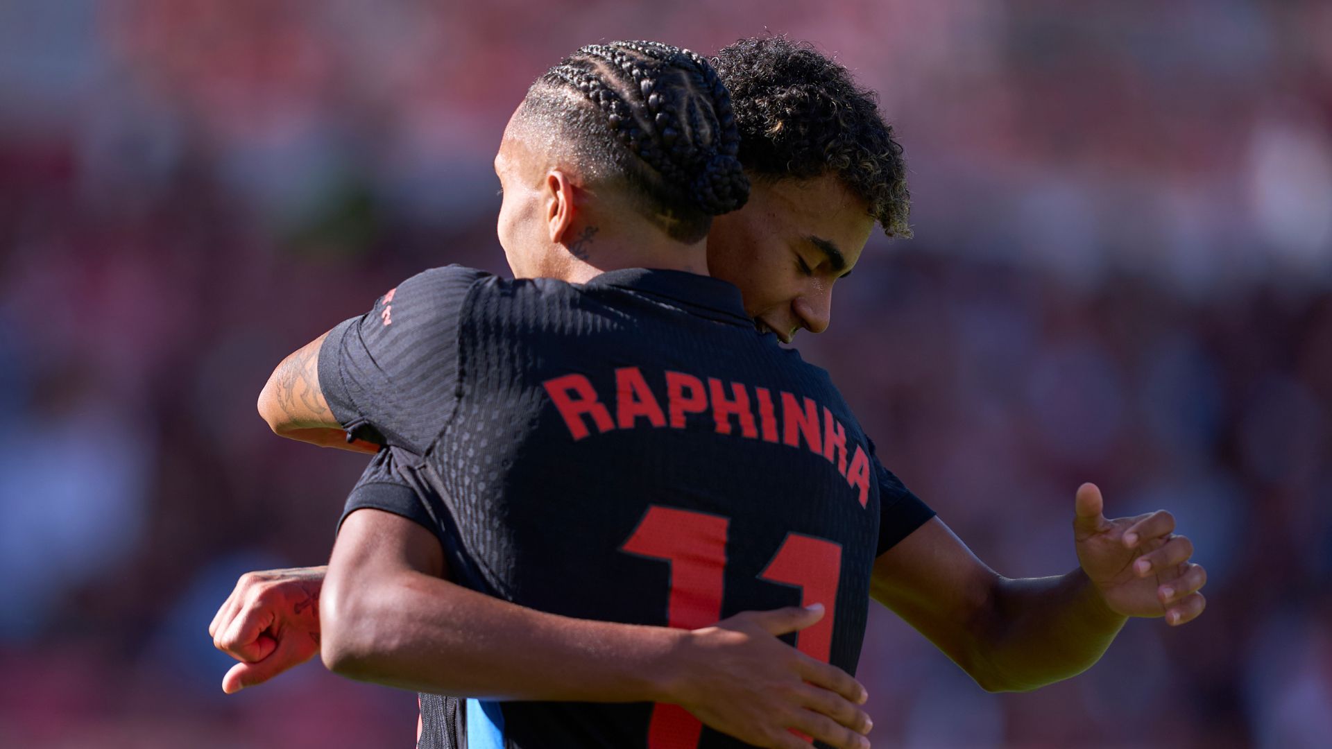Lamine Yamal abraçado com Raphinha, durante partida entre Barcelona e Girona