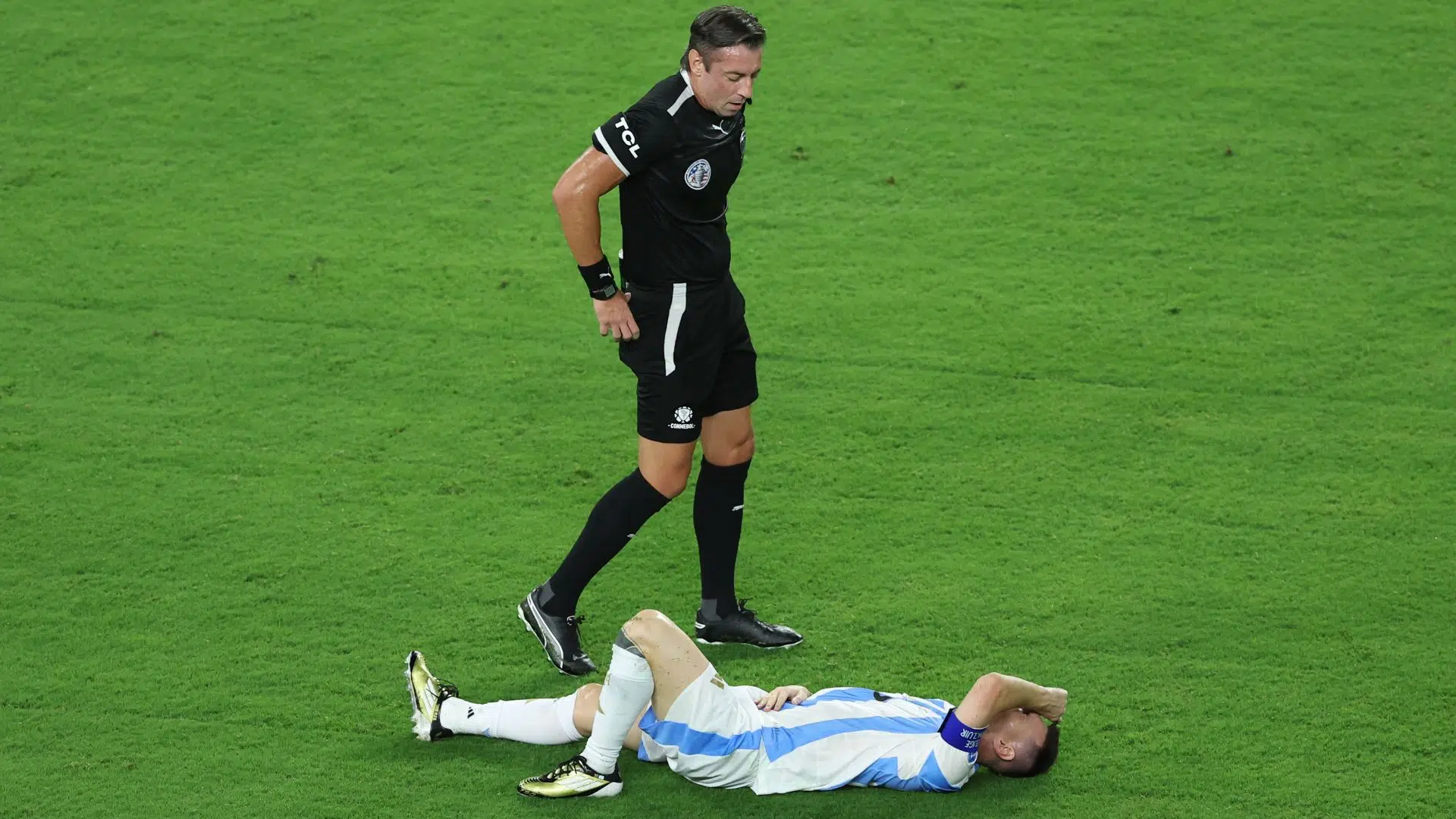 Lionel Messi caído no chão, com dores no tornozelo, na final da Copa América
