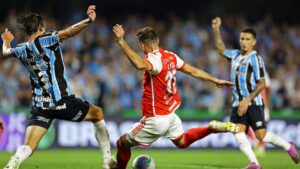 Lucas Alario, do Internacional, e Pedro Geromel, do Grêmio, disputam a posse de bola em partida válida pelo Campeonato Brasileiro