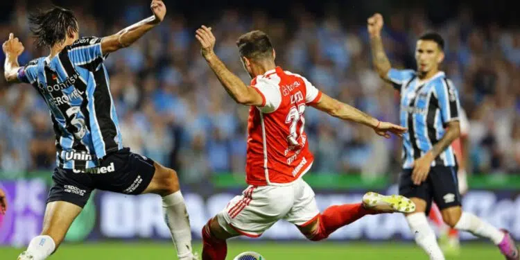 Lucas Alario, do Internacional, e Pedro Geromel, do Grêmio, disputam a posse de bola em partida válida pelo Campeonato Brasileiro