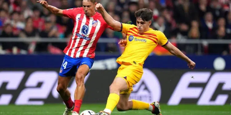 Marcos Llorente, do Atlético de Madrid, e Pau Cubarsí, do Barcelona, disputam a posse de bola durante partida válida por La Liga