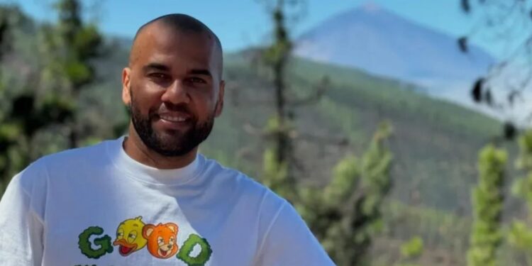 Daniel Alves, ex-jogador, posa para uma foto em seu Instagram, com montanhas ao fundo e uma camiseta com a mensagem "Bons momentos estão a caminho"