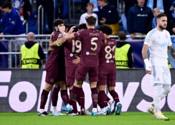Jogadores do Manchester City se abraçam e comemoram o primeiro gol do time, em jogo contra o Slovan Bratislava, válido pela Champions League