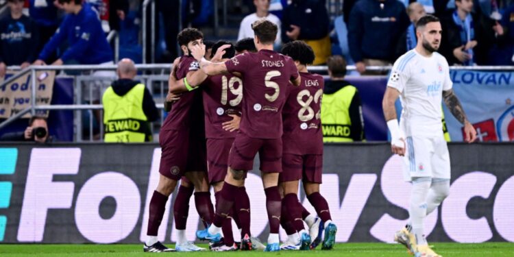 Jogadores do Manchester City se abraçam e comemoram o primeiro gol do time, em jogo contra o Slovan Bratislava, válido pela Champions League