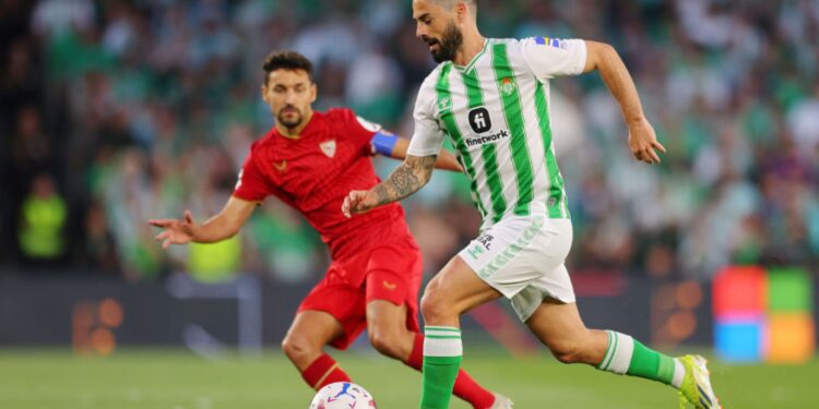 Isco, do Real Betis, corre com a bola enquanto Jesus Navas, do Sevilla, o persegue na marcação