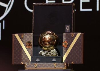 Foto do troféu Bola de Ouro sendo apresentado dentro de uma mala do Louis Vuitton