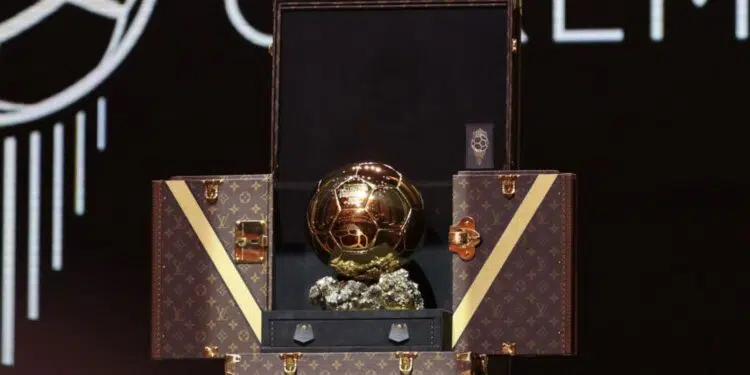 Foto do troféu Bola de Ouro sendo apresentado dentro de uma mala do Louis Vuitton