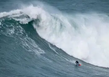 Foto do surfista Willyam Santana pegando uma onda gigante em Nazaré, Portugal