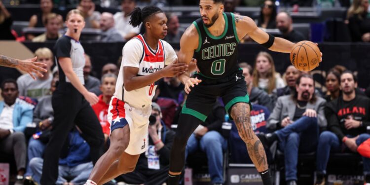 Jayson Tatum, do Boston Celtics, carrega a bola enquanto Bilal Coulibaly, do Washington Wizards, o marca