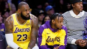 Bronny James sentado no banco de reservas ao lado do pai LeBron James