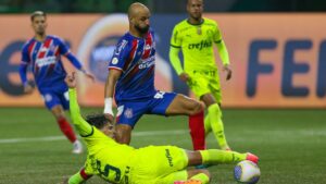 Thaciano, do Bahia, carrega a bola enquanto Gustavo Gómez, do Palmeiras, dá um carrinho tentando tirá-la