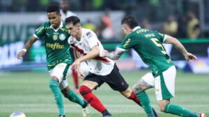 Shaylon, do Atlético-GO, tenta manter a posse de bola enquanto é marcado por Estêvão e Aníbal Moreno, do Palmeiras.