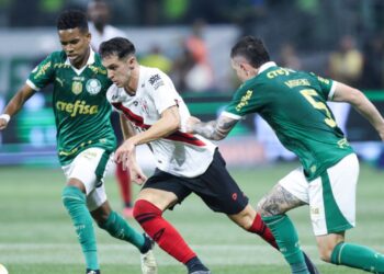Shaylon, do Atlético-GO, tenta manter a posse de bola enquanto é marcado por Estêvão e Aníbal Moreno, do Palmeiras.