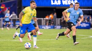 Bruno Guimarães, do Brasil, carrega a bola enquanto Ugarte, do Uruguai, o persegue