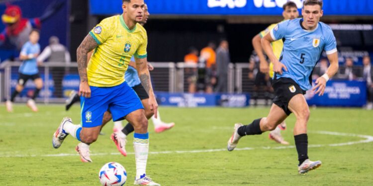 Bruno Guimarães, do Brasil, carrega a bola enquanto Ugarte, do Uruguai, o persegue