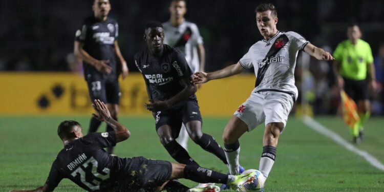 Damian Suárez, do Botafogo, dá um carrinho e tenta tirar a posse de bola de Lucas Piton, do Vasco, na partida do primeiro turno do Brasileirão 2024