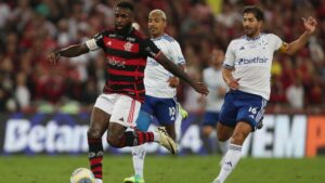 Gerson, do Flamengo, tenta manter a posse de bola enquanto Matheus Pereira e Lucas Silva, do Cruzeiro, marcam-no