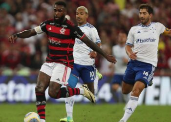 Gerson, do Flamengo, tenta manter a posse de bola enquanto Matheus Pereira e Lucas Silva, do Cruzeiro, marcam-no