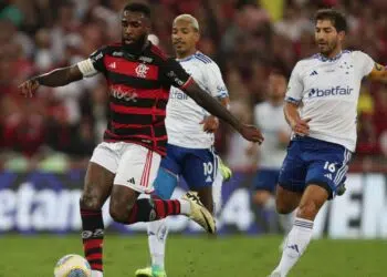 Gerson, do Flamengo, tenta manter a posse de bola enquanto Matheus Pereira e Lucas Silva, do Cruzeiro, marcam-no