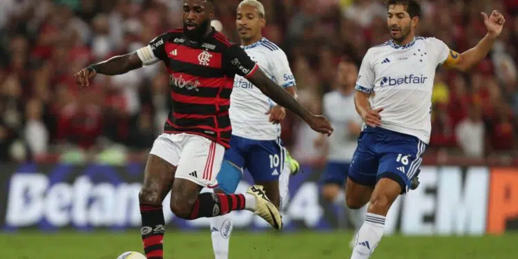 Gerson, do Flamengo, tenta manter a posse de bola enquanto Matheus Pereira e Lucas Silva, do Cruzeiro, marcam-no
