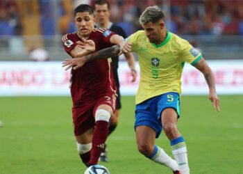 Bruno Guimarães e Savarino disputando por posse de bola, em Venezuela x Brasil