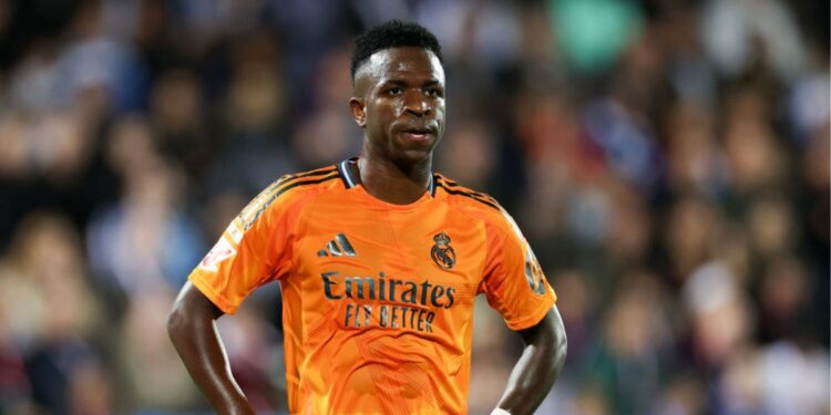 Vini Jr em ação pelo Real Madrid com o uniforme laranja em jogo de LaLiga