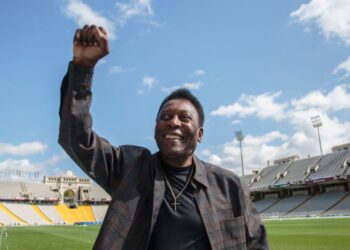 Pelé, ex-jogador brasileiro, faz sua comemoração característica, jogando o punho no ar