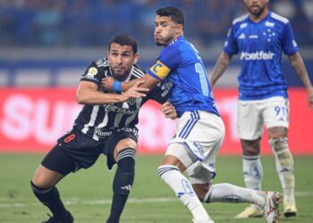 Junior Alonso, do Atlético-MG, e William, do Cruzeiro, disputam espaço em campo durante partida válida pelo Brasileirão 2024