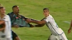 Lance no qual Tomás Cuello puxa a camisa de Gustavo Vilar dentro da área