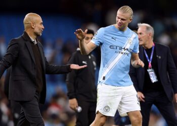 Guardiola e Haaland se cumprimentando em jogo do Manchester City