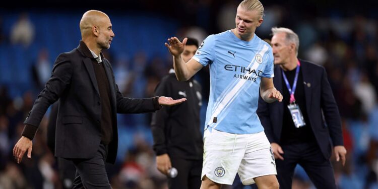 Guardiola e Haaland se cumprimentando em jogo do Manchester City