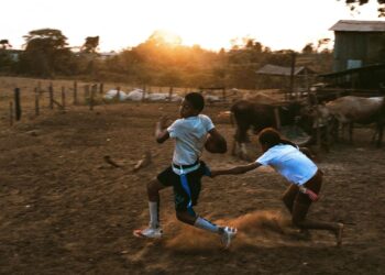Meninos jogando futebol americano