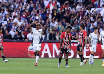 Enquanto jogadores do LDU comemoram gol, os do São Paulo lamentam