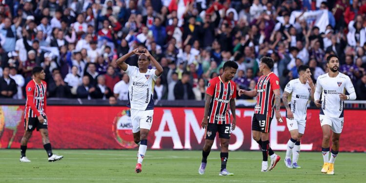 Enquanto jogadores do LDU comemoram gol, os do São Paulo lamentam