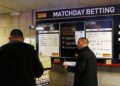 Apostas em esportes: Torcedores fazendo apostas na Premier League