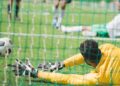 Goleiro pulando na bola em partida de futebol - Créditos: depositphotos.com / ArturVerkhovetskiy
