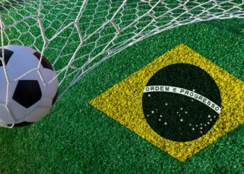 Bola na rede ao lado de bandeira da seleção brasileira - Créditos: depositphotos.com / suriyaphoto