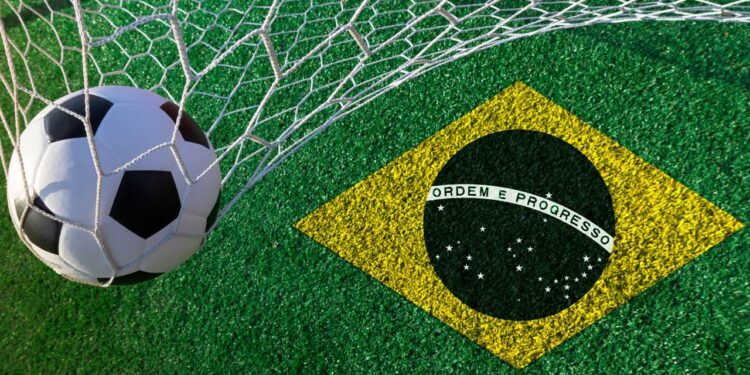 Bola na rede ao lado de bandeira da seleção brasileira - Créditos: depositphotos.com / suriyaphoto