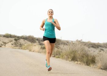 Mulher fazendo treino de corrida em estrada de terra - Créditos: depositphotos.com / focuspocusltd