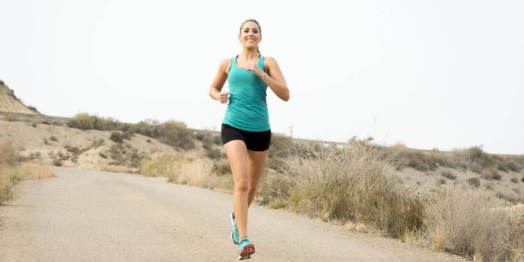 Mulher fazendo treino de corrida em estrada de terra - Créditos: depositphotos.com / focuspocusltd
