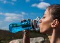 Mulher bebendo água durante corrida - Créditos: depositphotos.com / IgorVetushko