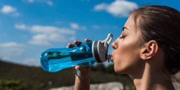 Mulher bebendo água durante corrida - Créditos: depositphotos.com / IgorVetushko