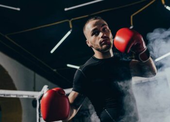 Lutador com luvas no ringue - Créditos: depositphotos.com / IgorTishenko