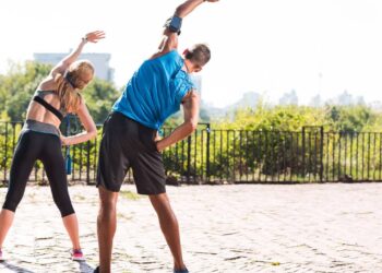 Casal alongando - Créditos: depositphotos.com / ArturVerkhovetskiy